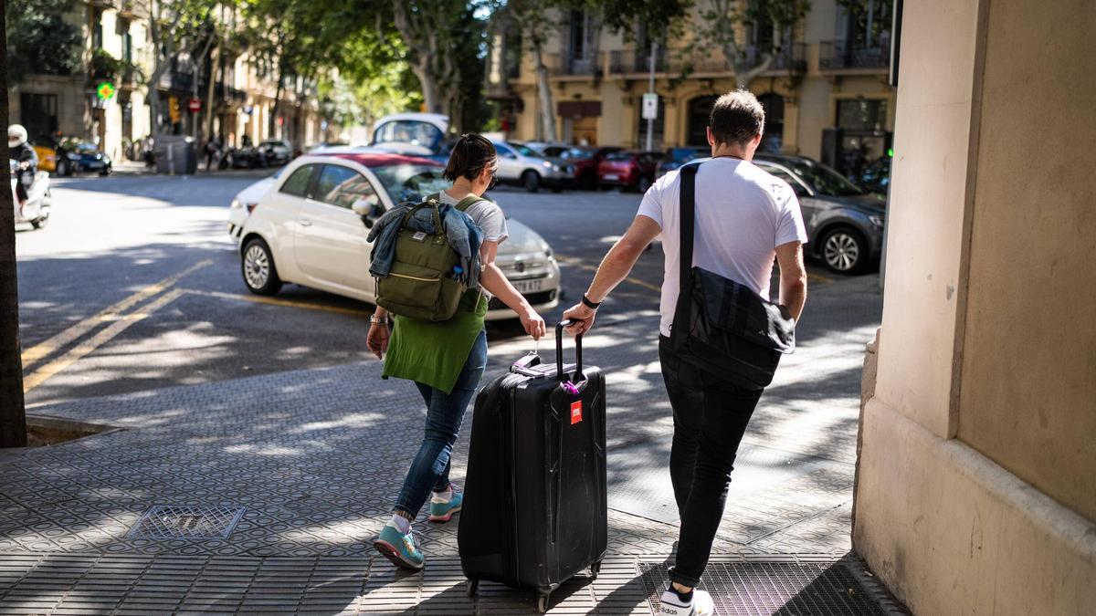 Turistas con maletas por el centro de Barcelona.