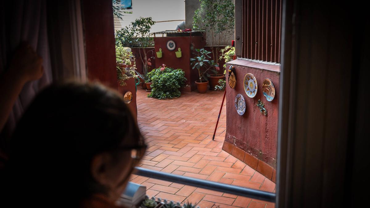 Una vecina abre la puerta del patio interior donde se precipitaron las dos hermanas, Núria i Mercè, horas antes de ser desahuciadas.