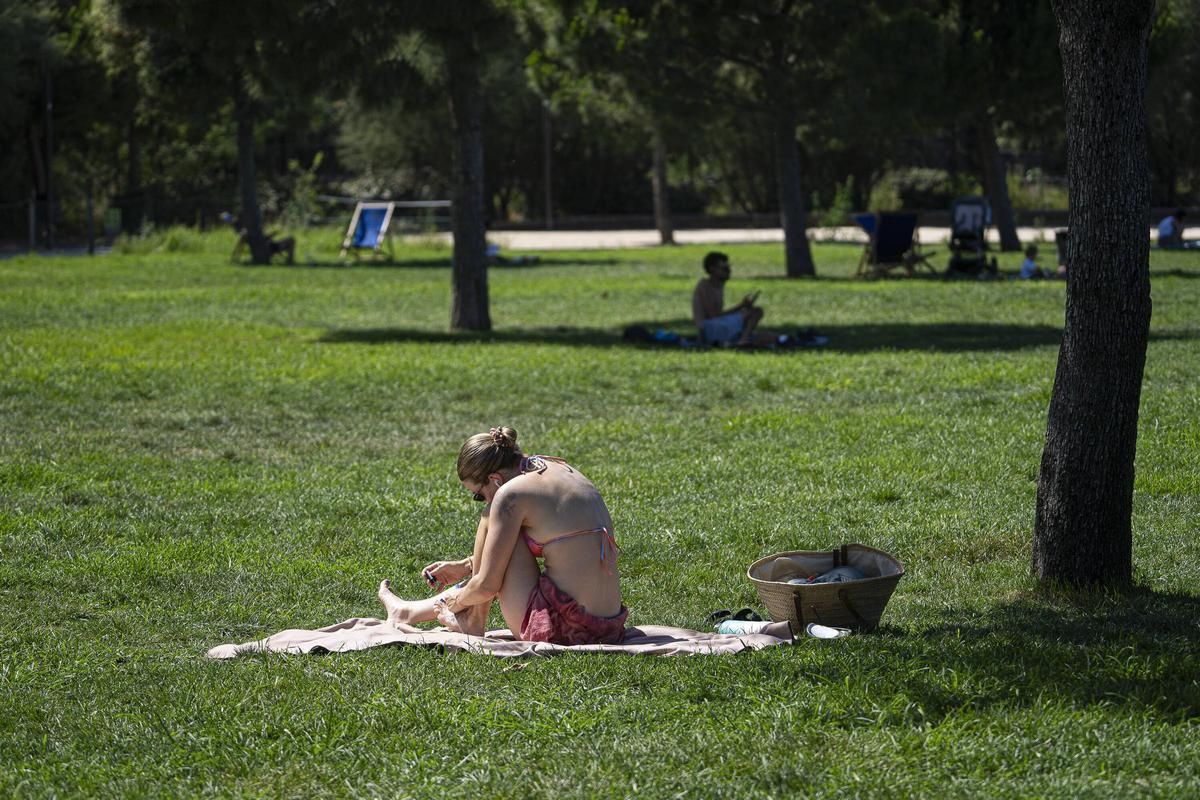 Une jeune femme prend un bain de soleil en bikini sur l'herbe à Clariana de Glòries.