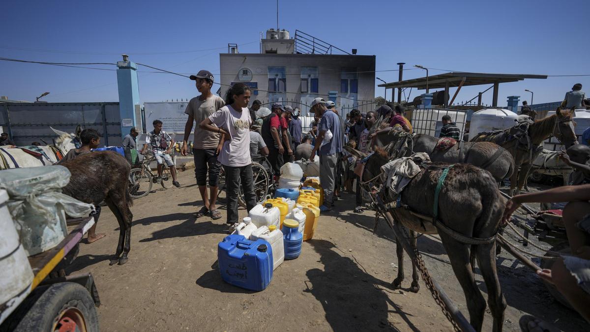 Palestinos intentan conseguir agua en la Franja de Gaza, en  Deir al Balah.