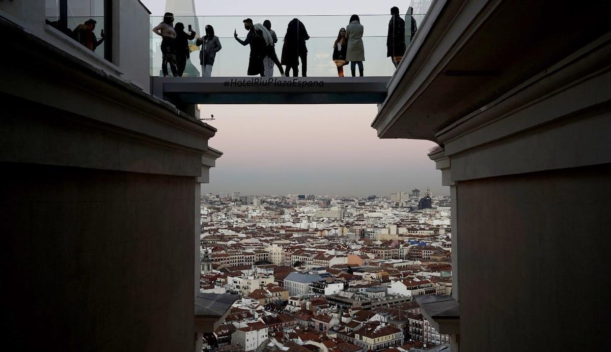Touristes prenant des selfies sur la passerelle aérienne de l'hôtel Riu sur la Plaza de España à Madrid