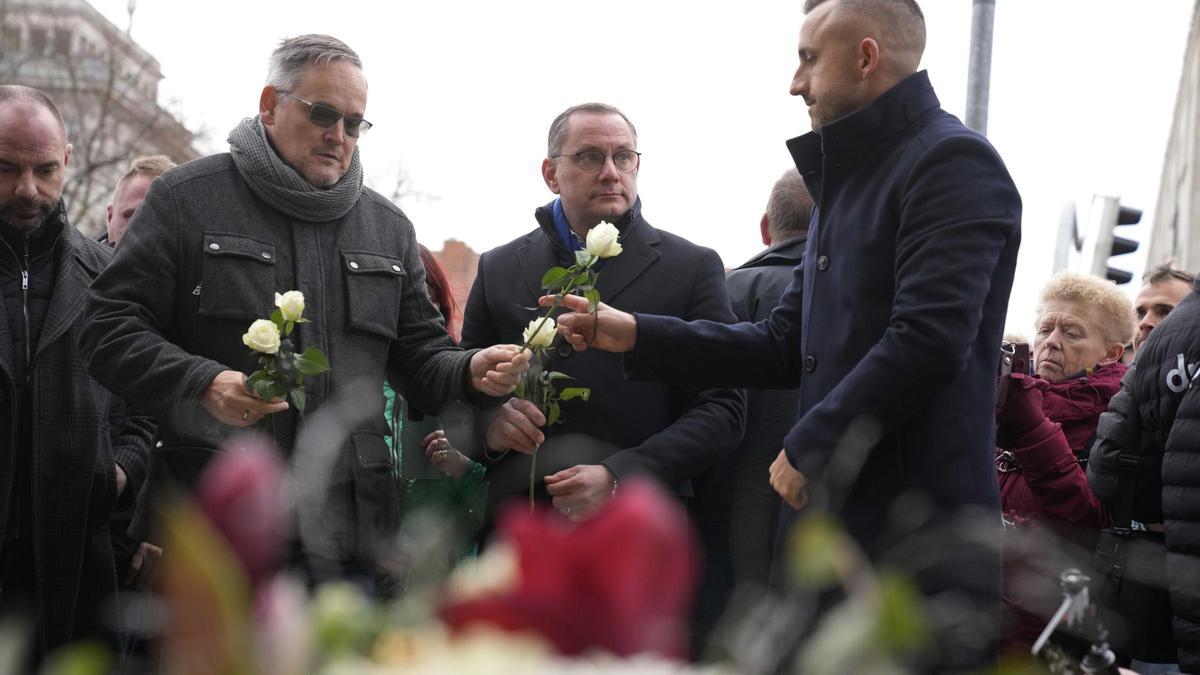 El colíder de AfD, Tino Chrupalla (centro), deposita flores en el lugar del atentado en Magdeburgo, Alemania.