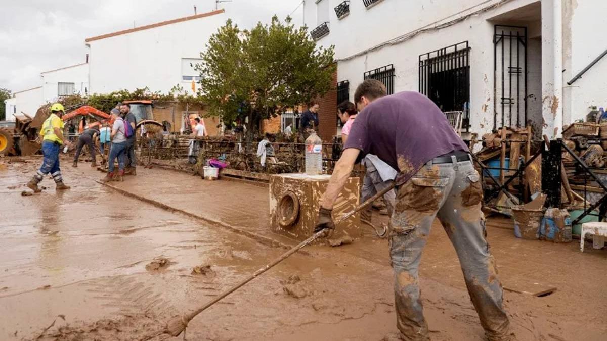 Varias personas ayudan a limpiar las calles tras el paso de la DANA.