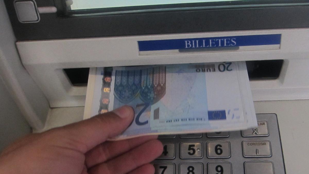 Una persona retira efectivo de un cajero automático.