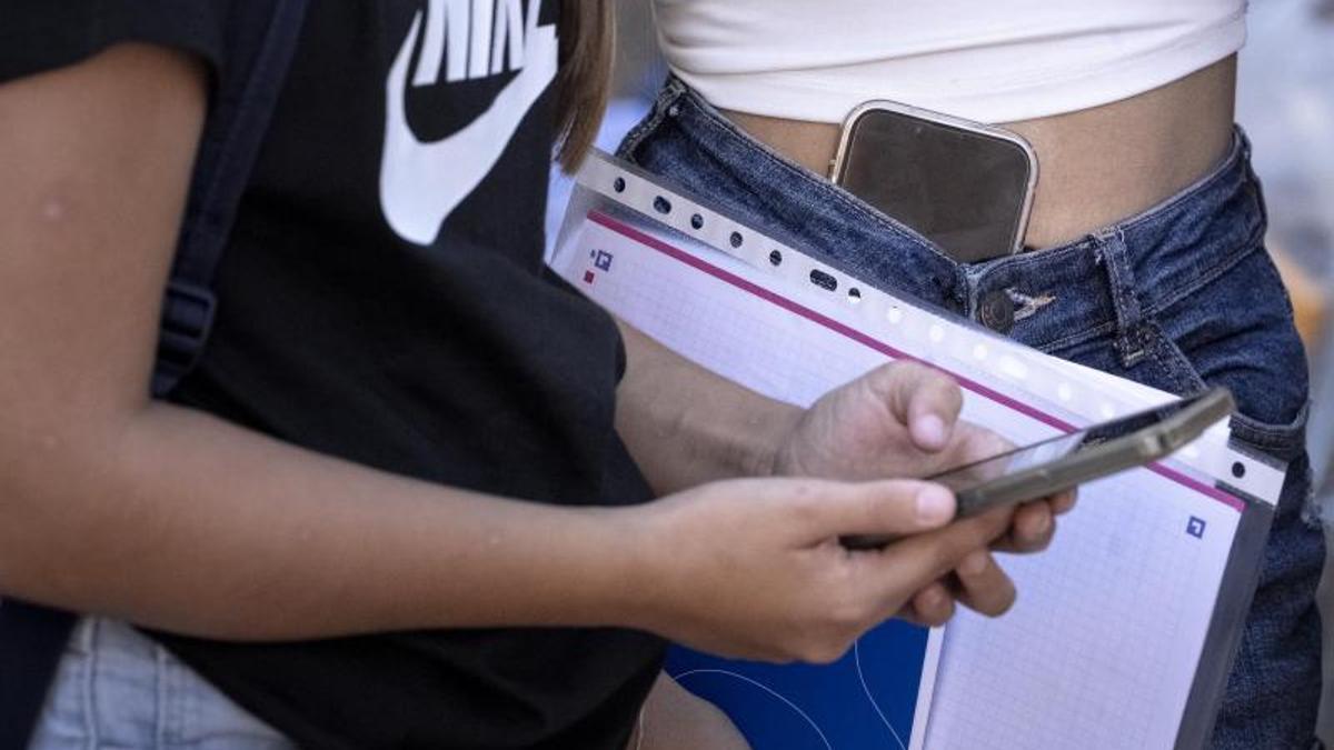 Alumnas de ESO, con sus móviles a la salida de clase.