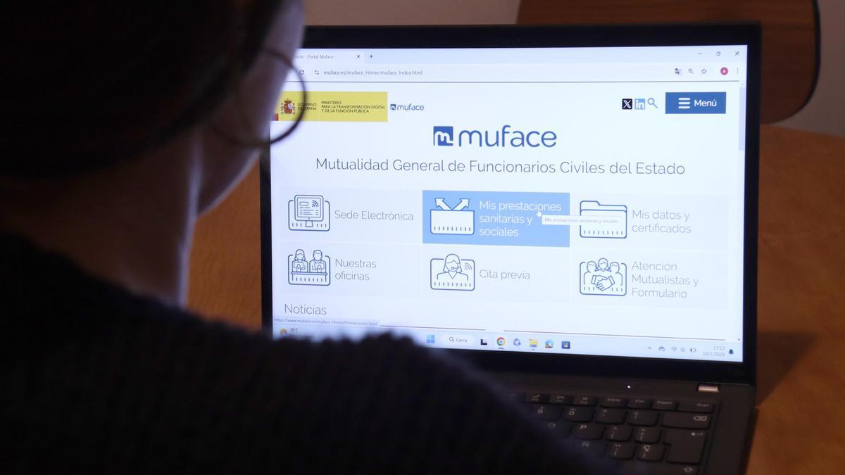 Una persona mirando la web de Muface.