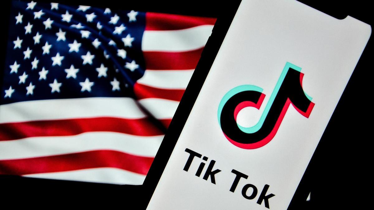 El logotipo de TikTok aparece en la pantalla de un teléfono con la bandera de Estados Unidos de fondo