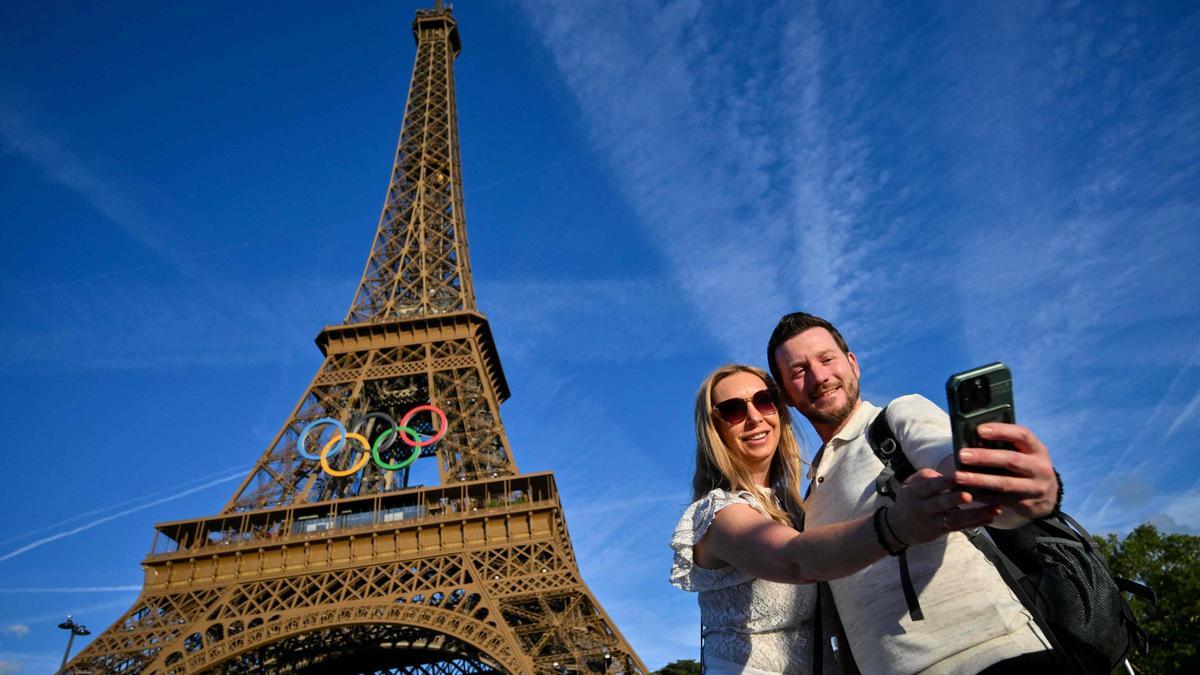 Dos turistas se fotografían con la torre Eiffel de fondo