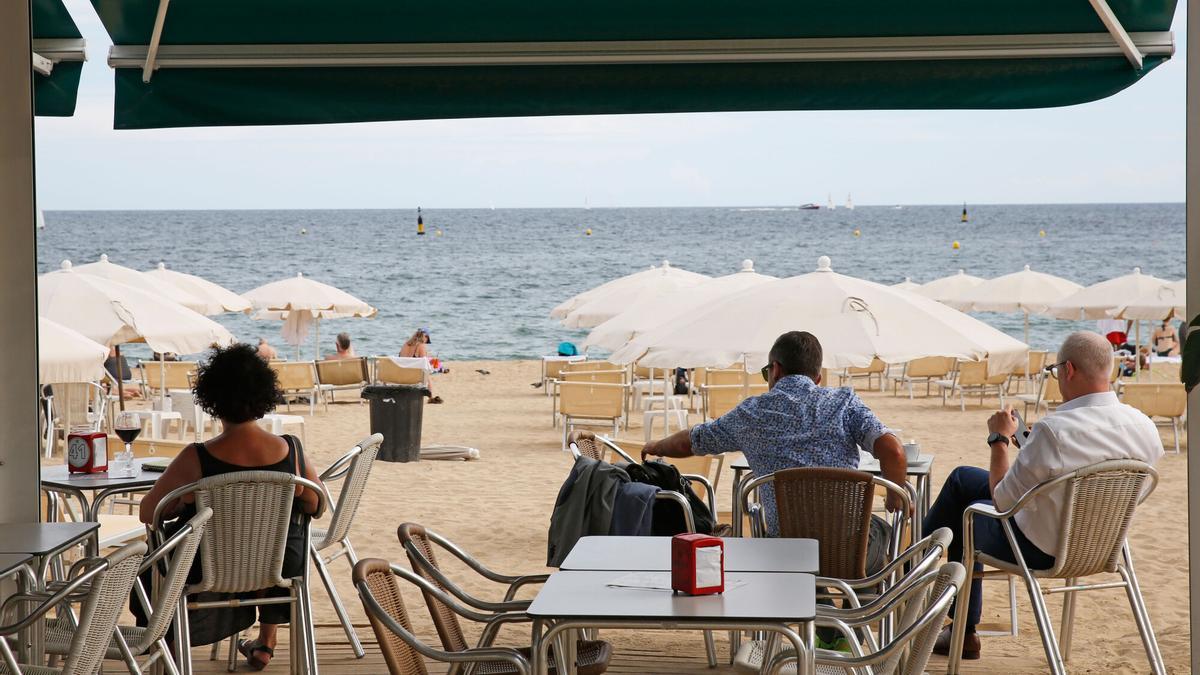 Turistas sentados en un chiringuito de playa.
