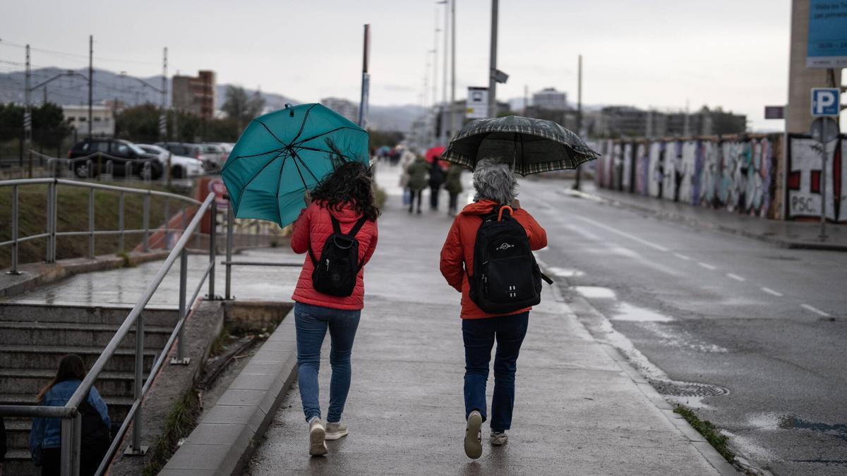 Vecinos del barrio de Sant Adrià con paraguas.