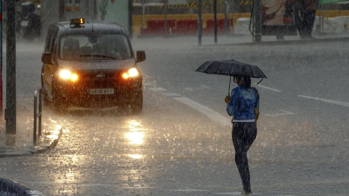 Mujer caminando bajo fuertes lluvias en Barcelona