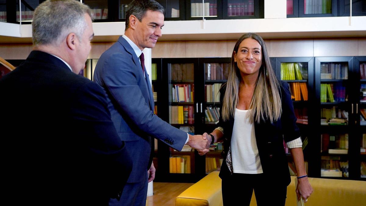 El presidente del Gobierno, Pedro Sánchez, y la portavoz de Junts, Míriam Nogueras, se saludan en presencia del secretario de Organización del PSOE, Santos Cerdán, en octubre de 2023.