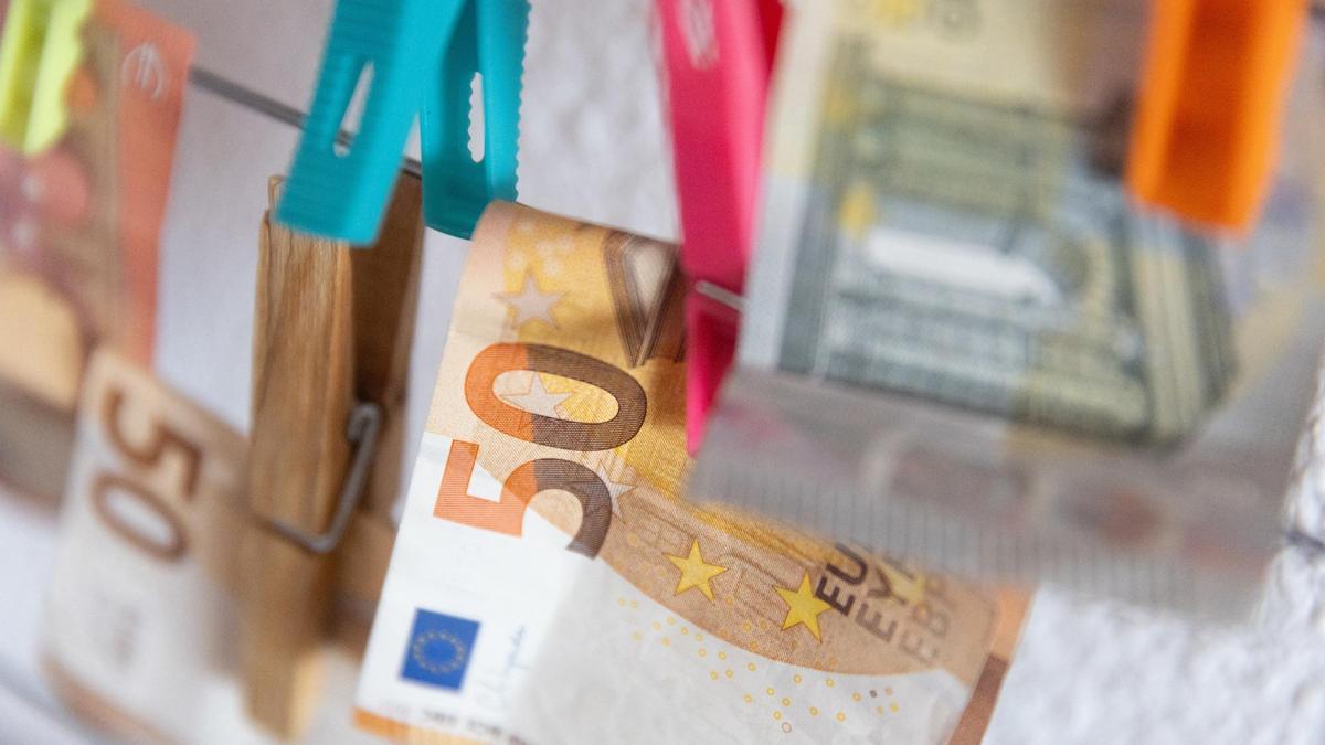 Archivo - Varios billetes sujetos con pinzas.