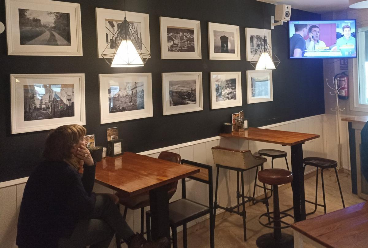 Une femme observe la télévision dans un bar osseux.