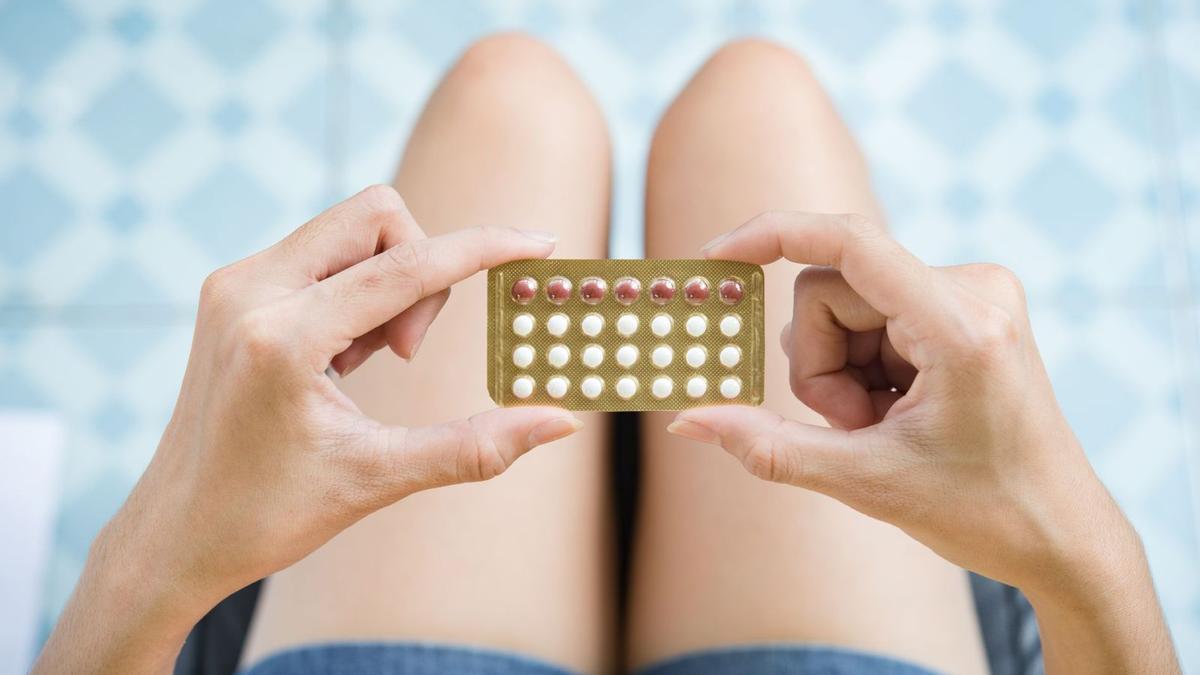 Una mujer sostiene un blíster de píldoras anticonceptivas.