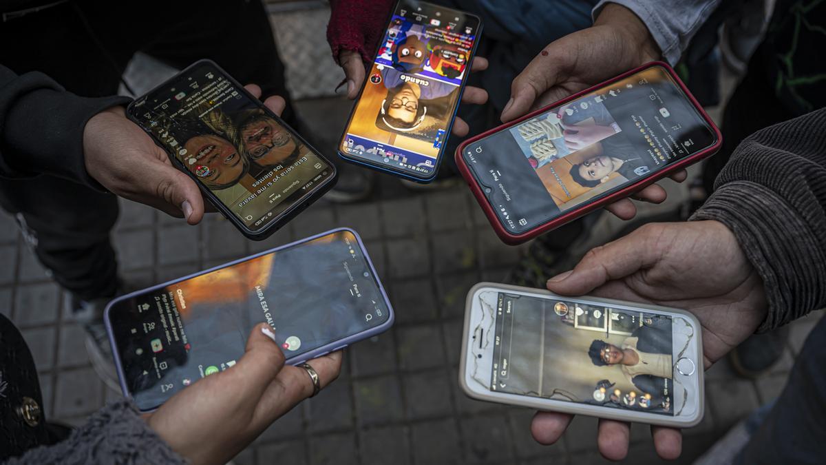 Un grupo de jóvenes, usando TikTok en la calle, en Barcelona.