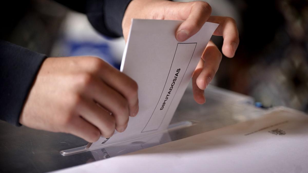 Un elector introduce su papeleta en una mesa de votación durante las últimas elecciones generales.