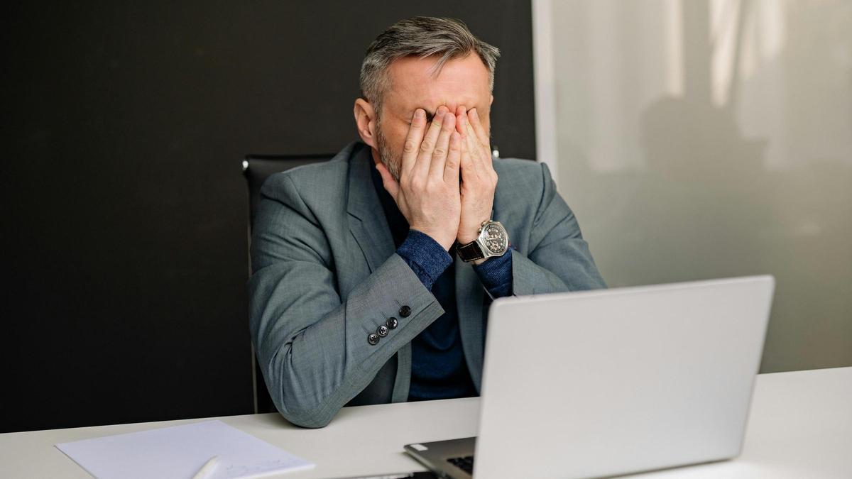 Un hombre estresado en su puesto de trabajo.