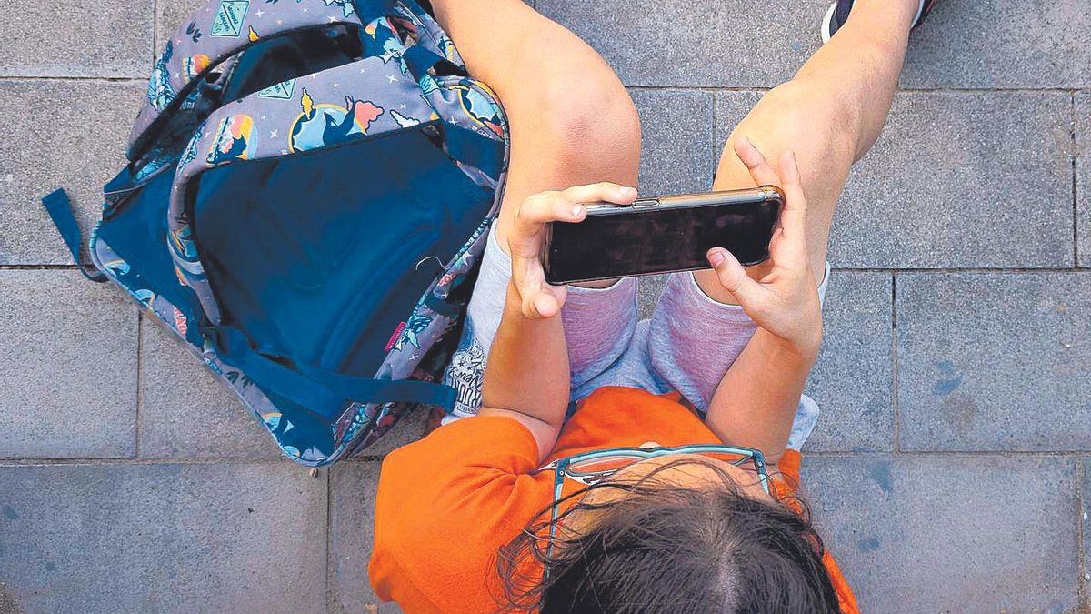 Un niño consulta el móvil.
