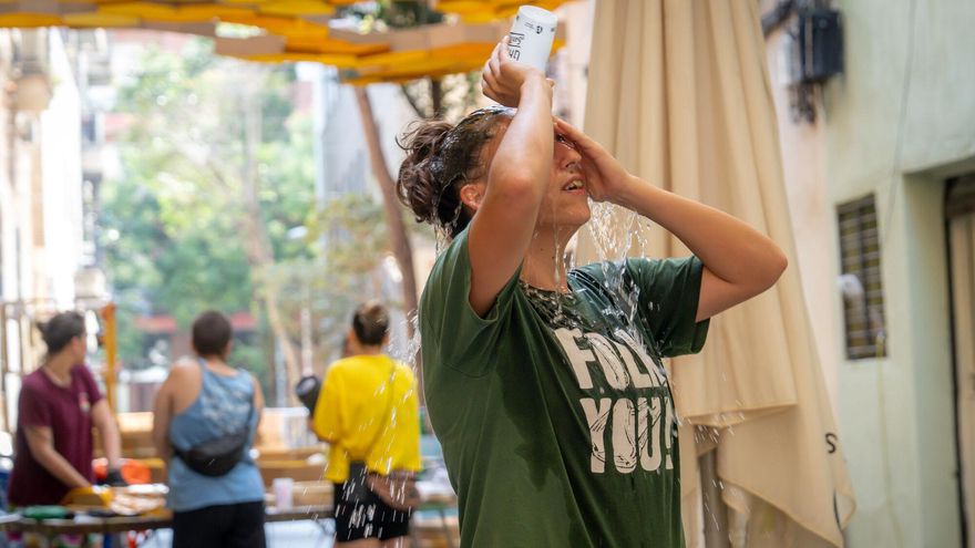 Mujer refrescándose en plena ola de calor en Barcelona.