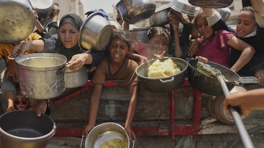 Los palestinos intentan conseguir comida en una cocina comunitaria en la Ciudad de Gaza.