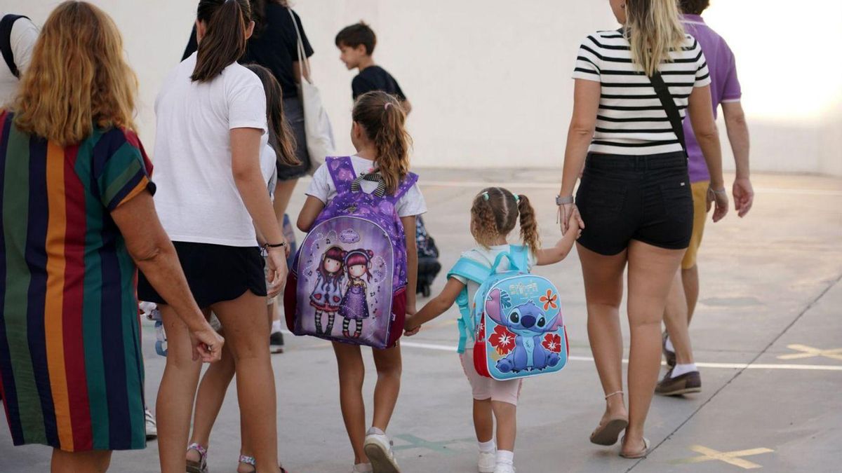 Varios niños llegan al colegio acompañados de sus madres.
