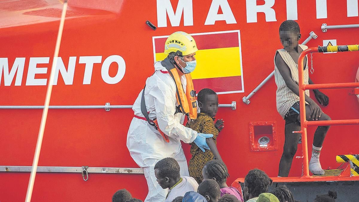 Un miembro de Salvamento Marítimo ayuda a un menor migrante en el puerto de La Restinga, en El Hierro, en noviembre del 2024.