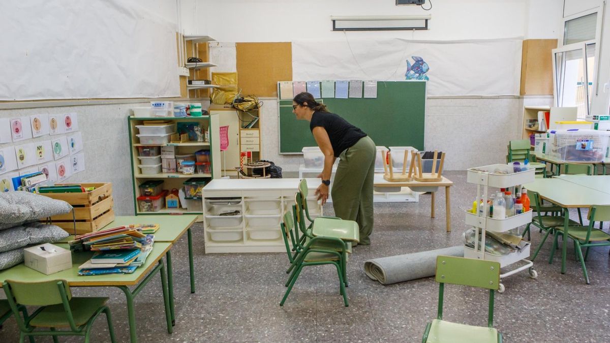 Una maestra prepra un aula de infantil en un instituto-escuela en Catalunya.