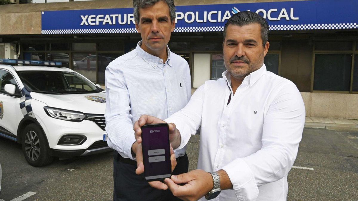 El economista Manuel Montenegro (i) y el policía local de Vigo David Calvo (d), junto a la app patentada en las instalaciones de la Jefatura.