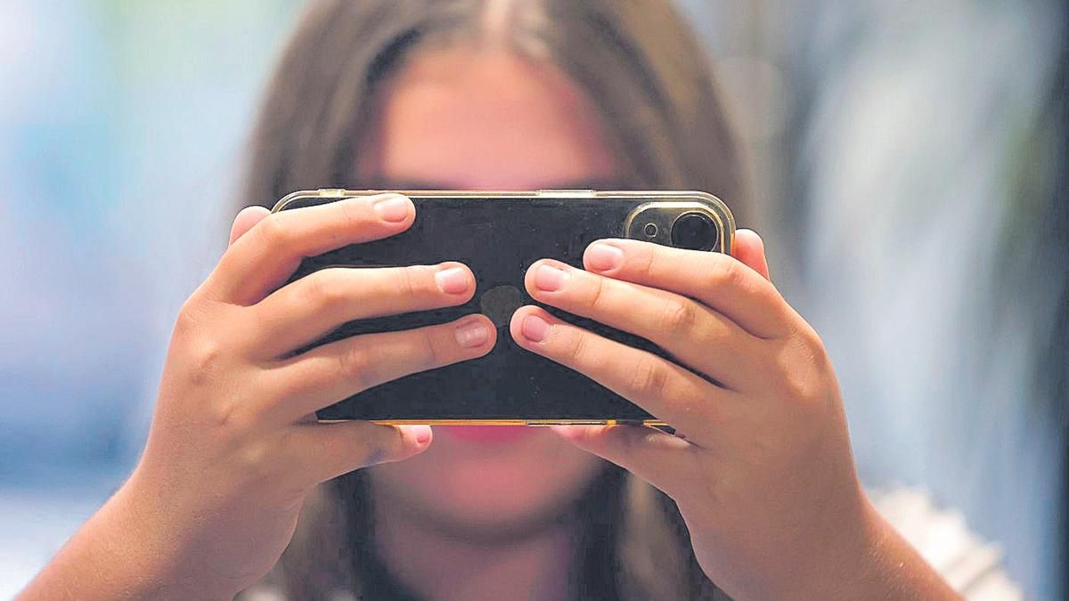 Una adolescente con un móvil.