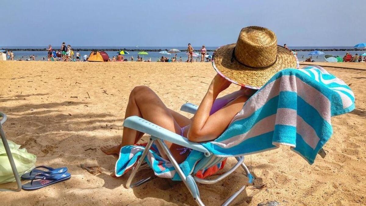 Una mujer se refresca en una playa de Canarias.