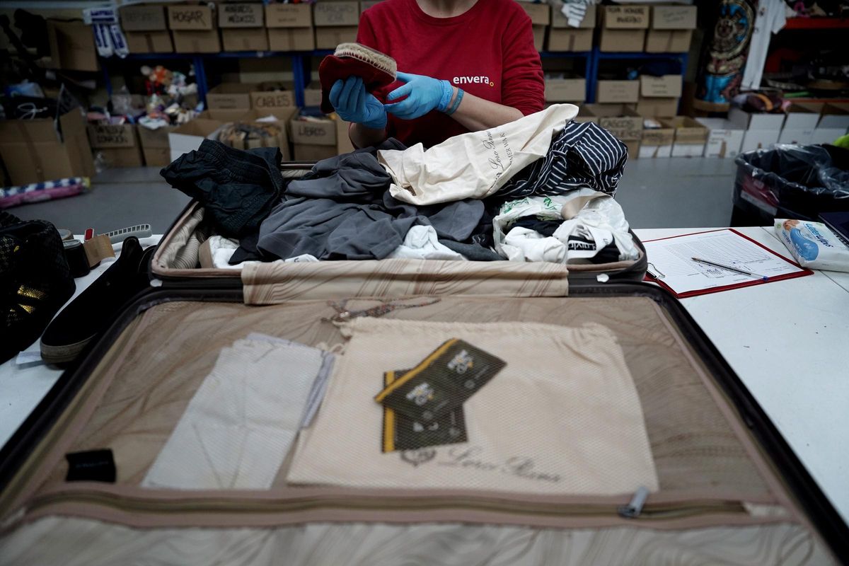 Un employé de la Fondation Envera vérifie l'une des valises perdues dans un aéroport espagnol.