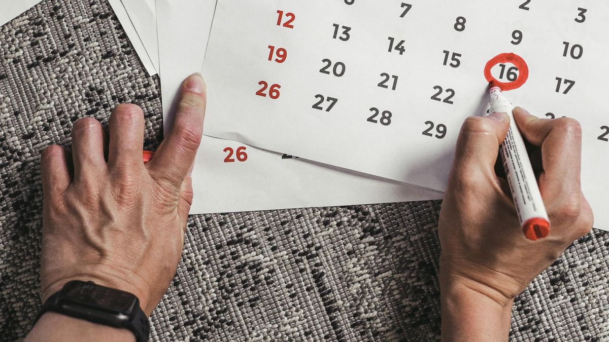 Un trabajador señala un día en un calendario.