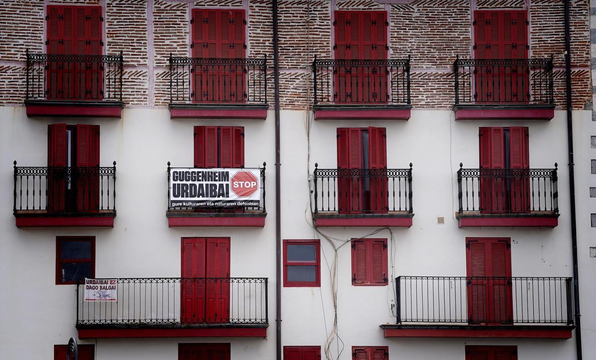 Vue d'une façade d'appartement à Mundaka, avec une pancarte contre l'agrandissement du musée Guggenheim dans la réserve de biosphère d'Urdaibai.