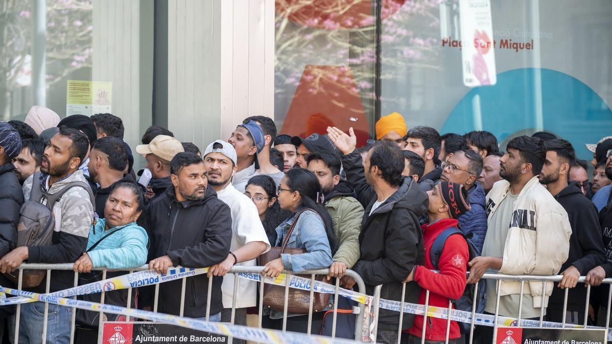 Cola para los trámites de la regularización de inmigrantes en la oficina de atención ciudadana de la plaza de Sant Miquel de Barcelona.