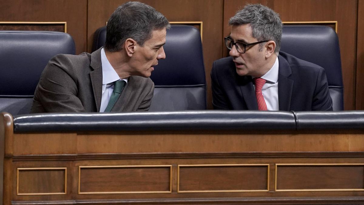 El presidente del Gobierno, Pedro Sánchez, conversa con el ministro de Presidencia y Justicia, Félix Bolaños, durante el pleno extraordinario de este martes en el Congreso.
