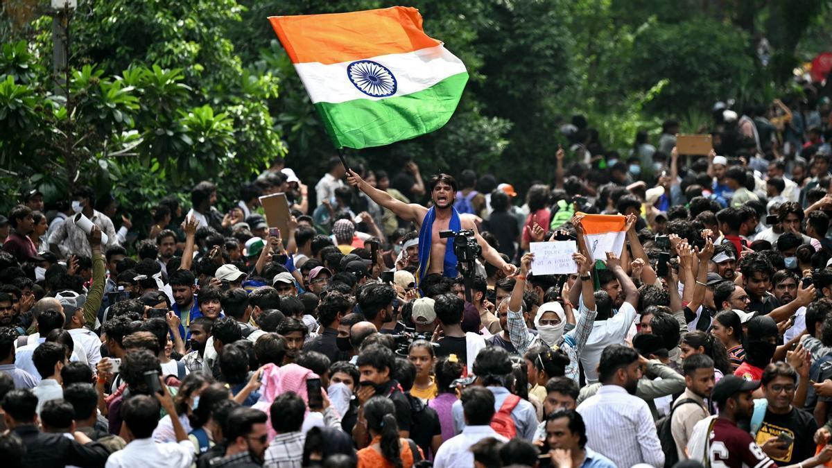 Miembros del Cockroach Janta Party (CJP) celebran la dimisión del ministro de Educación, Dharmendra Pradhan en Nueva Delhi.