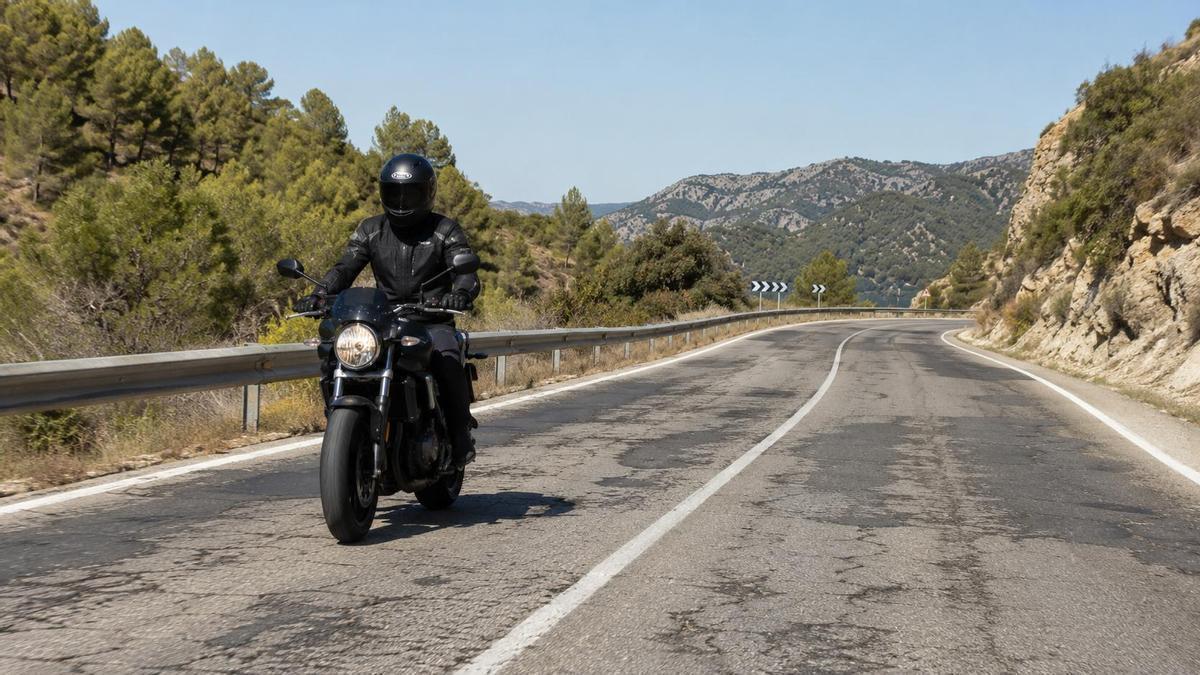 Un motorista circula por una carretera con el firme en mal estado.