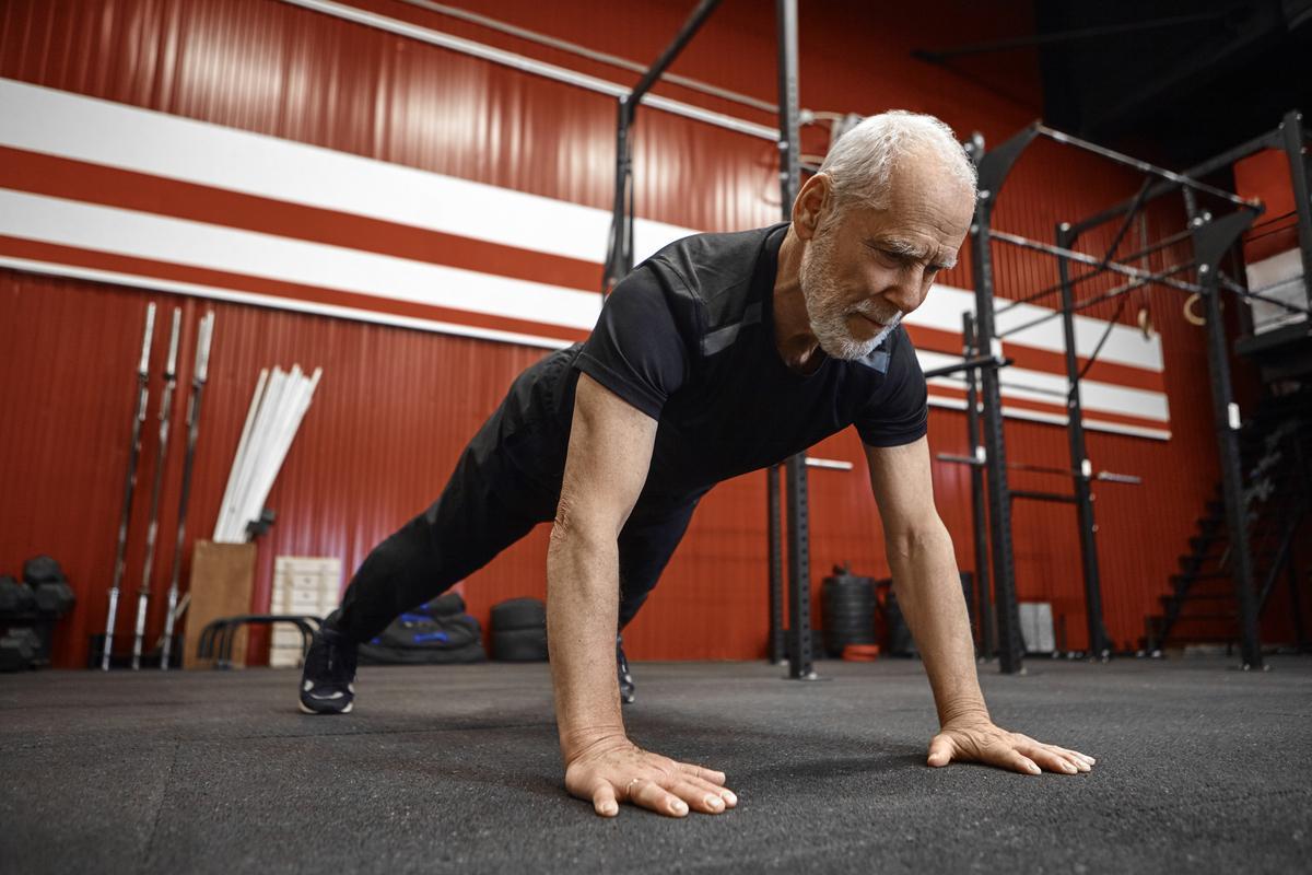 Un athlète senior fait des pompes