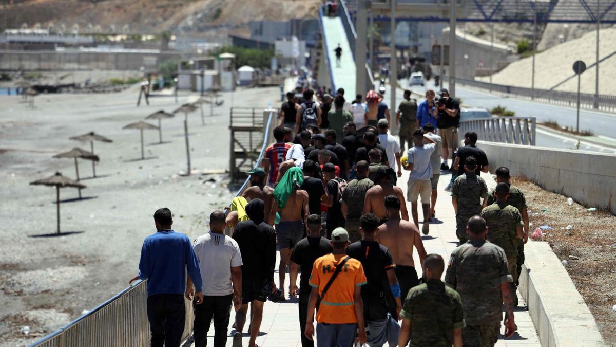 Migrantes junto a la playa de Ceuta