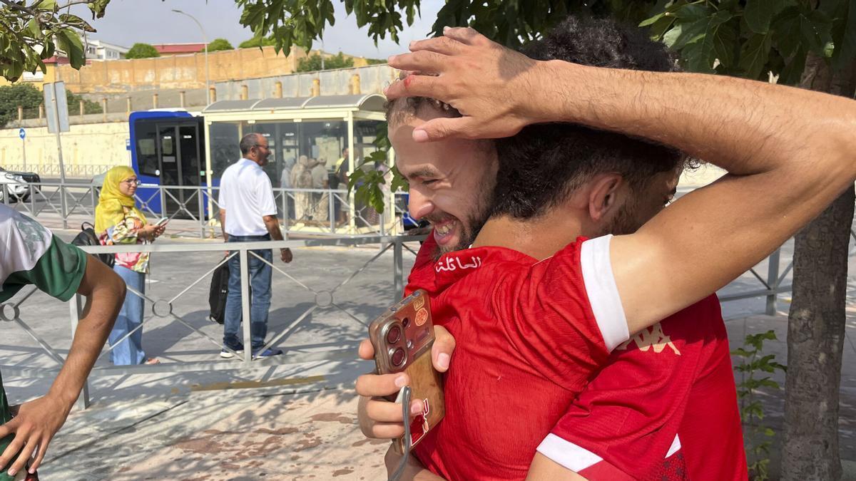 Dos jóvenes se abrazan en Ceuta, tras cruzar la frontera desde Marruecos.