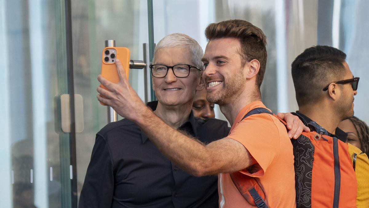 Imagen de archivo del director ejecutivo de Apple, Tim Cook, posando para una foto con un cliente en Nueva York.