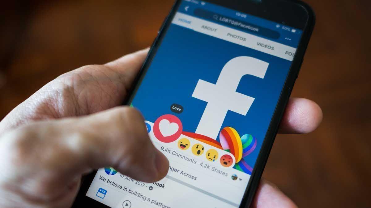 Une personne interagissant avec l'application Facebook sur son téléphone mobile. UTILISATEURS. RÉSEAUX SOCIAUX