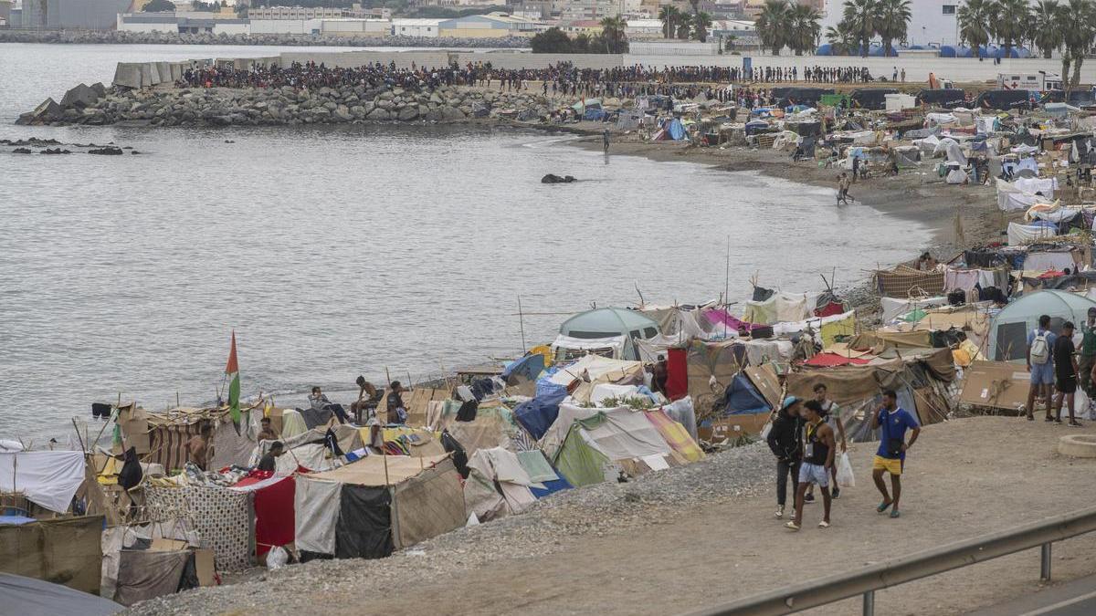 Varios inmigrantes acampados en una playa, a 1 de septiembre de 2026, en Ceuta (España).