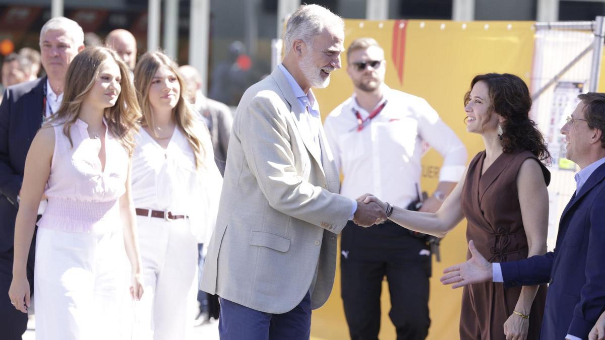 El rey Felipe VI (c) saluda a la presidenta de la Comunidad de Madrid, Isabel Díaz Ayuso (2d) y al alcalde de Madrid, José Luis Martínez-Almeida (d) a su llegada este domingo al Gran Premio de España de Fórmula Uno en el nuevo circuito de Madring en Madrid.