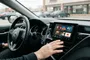 Interfaz de YouTube abierta en la pantalla central de un coche Toyota estacionado.