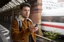 Hombre en la estación con el móvil.