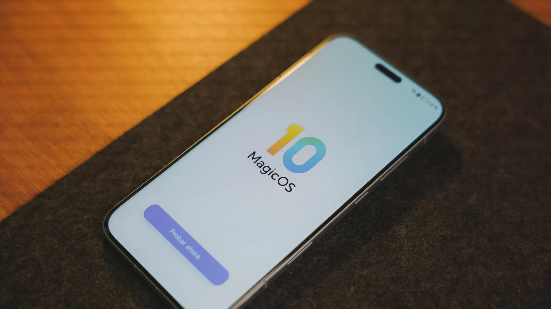 Écran avant du smartphone Honor Magic8 Pro avec le logo MagicOS 10 et un bouton d'accueil des paramètres sur une surface sombre.