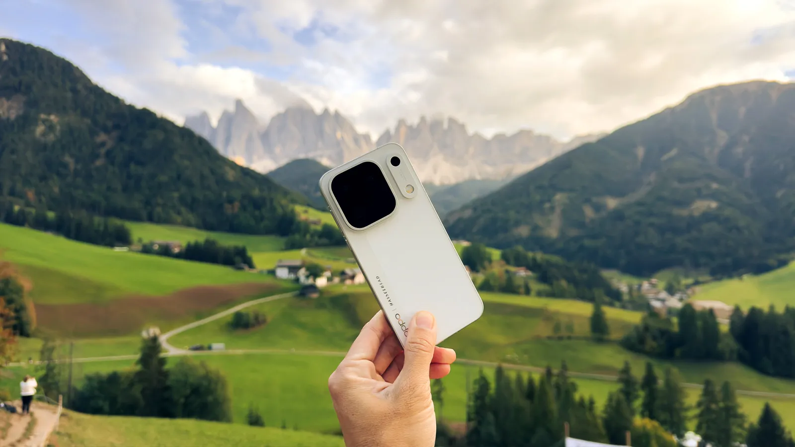 Arrière de l'OPPO Find X10 Pro en blanc, devant une vallée de montagne avec des sommets rocheux.