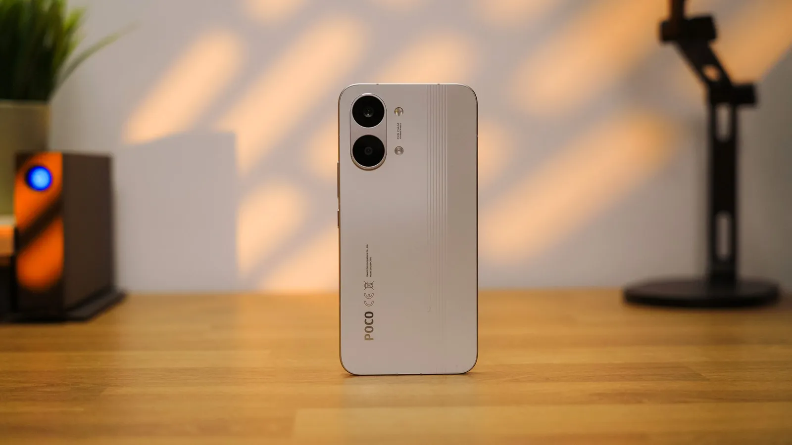 Dos du smartphone POCO X8 Pro Max en blanc avec son double module caméra vertical sur une table en bois.